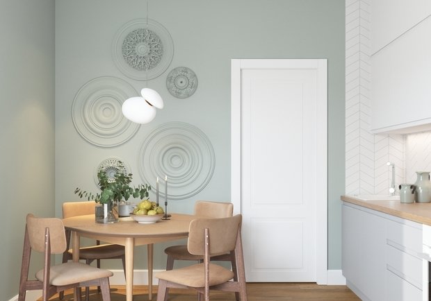 На кухне зону около обеденного стола необычно декорировали композицией из потолочных розеток.