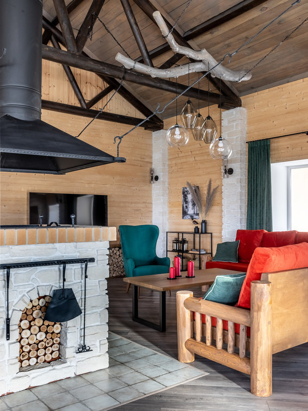 Массивные люстры из настоящих (найденных неподалеку от дома) коряг над обеденным столом и мягкой зоной были изготовлены самим заказчиком. Такие вещи придают индивидуальности пространству.