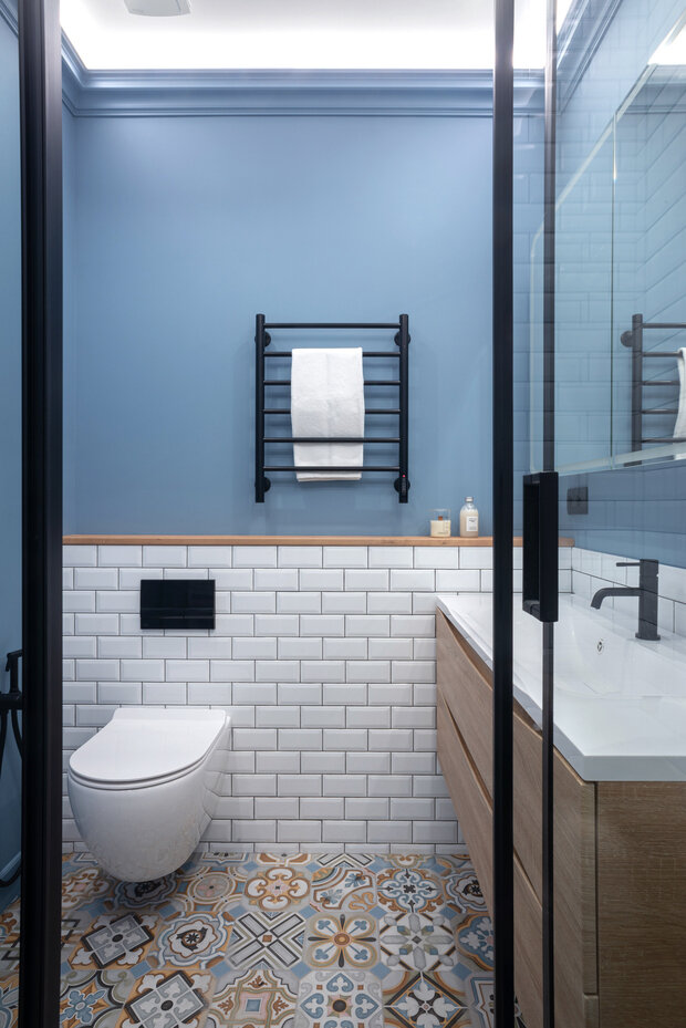 В интерьере санузла также прослеживаются контрастные черные детали и натуральное дерево.