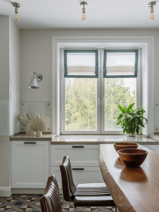 Кухня занимает свое изначальное место по плану БТИ. Плиту разместили так, чтобы ее не было видно из гостиной. Холодильник и мойка располагаются на пограничной территории, что оставляет к ним свободный доступ при готовке.