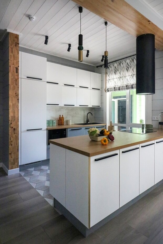 Планировка кухни — линейная. Одним из пожеланий хозяйки было не стоять спиной к гостям во время готовки. Таким образом, на внутренней части находится рабочая зона с холодильником и мойкой, внешняя линия — остров с варочной поверхностью, на нем удобно готовить и сервировать закуски.