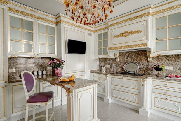 Интерьер кухни в классическом стиле с белыми фасадами и золотой отделкой
