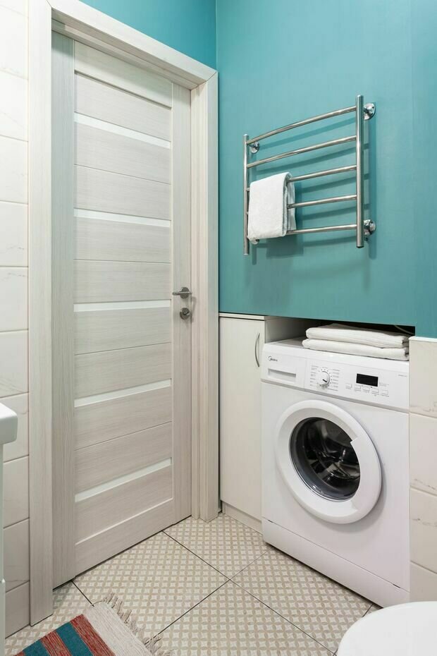 В санузле продолжили тему буйства красок, покрасив верхнюю часть стены влагостойкой голубой краской, нижнюю же часть стены успокоили белой плиткой, уложенной кирпичной кладкой.