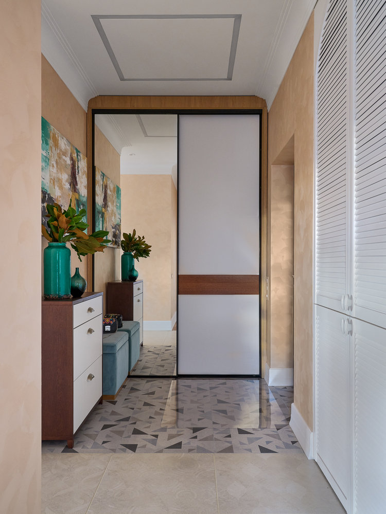 За арочными шаттерсами располагается кладовая со стиральной и сушильной машинами. Здесь также хранятся елка, пылесос, швабры. Дверцы сделали жалюзийными, чтобы происходило естественное проветривание кладовой.