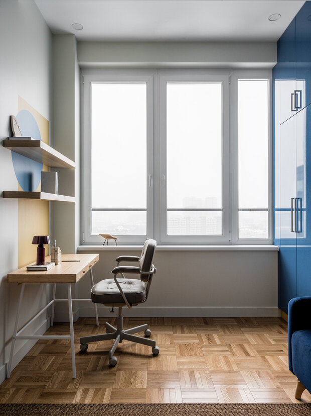 Рабочее место отделили от кухни перегородкой. Стену украсили геометрической росписью и разместили несколько полок.