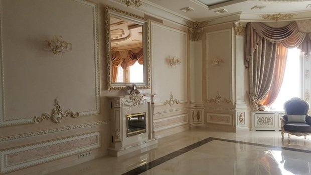 Интерьер гостиной в классическом стиле с лепниной и камином