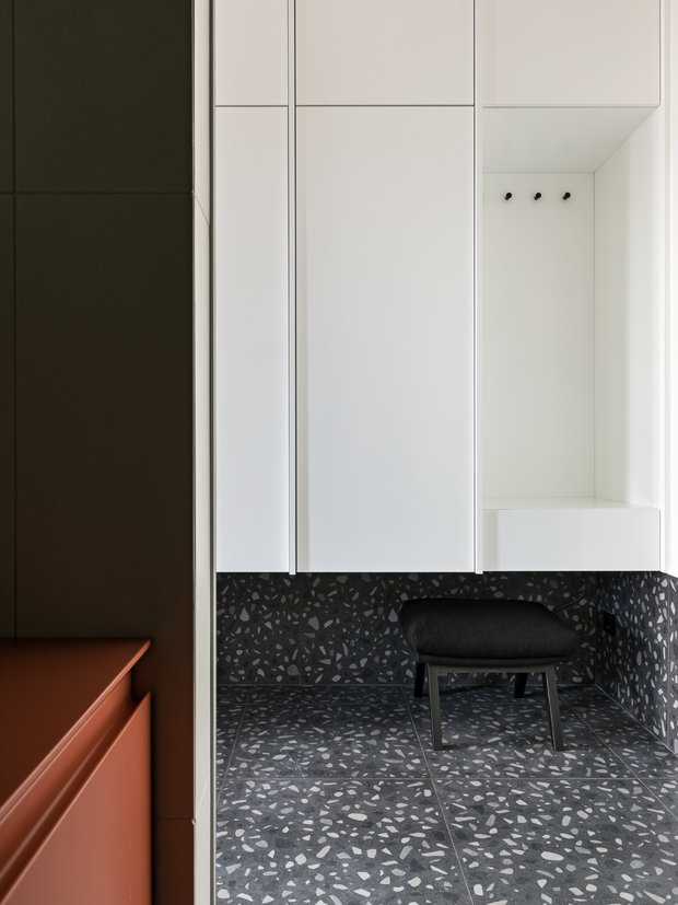 Керамогранит в прихожей немного завели на стены, так практичнее. Шкаф для верхней одежды сделали подвесным и в цвет стен.