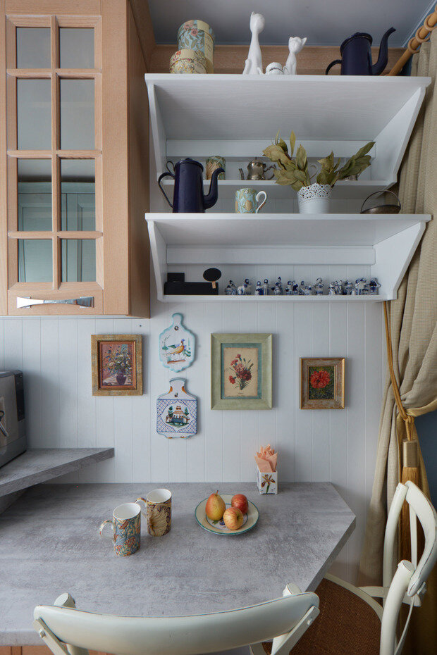 Для пола выбрали доску из натурального дерева. Стены покрасили и покрыли лаком, чтобы было проще ухаживать. На стене с гарнитуром использовали плитку, противоположную стену оформили деревянной панелью белого цвета.