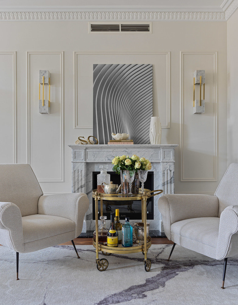 Биокамин с классическим порталом выполнен из каррарского мрамора. Картина над камином — фоторабота Егора Комарова, это вокзал Oculus в Нью-Йорке, построенный по проекту испанца Сантьяго Калатравы на месте разрушенной терактом 11 сентября станции.