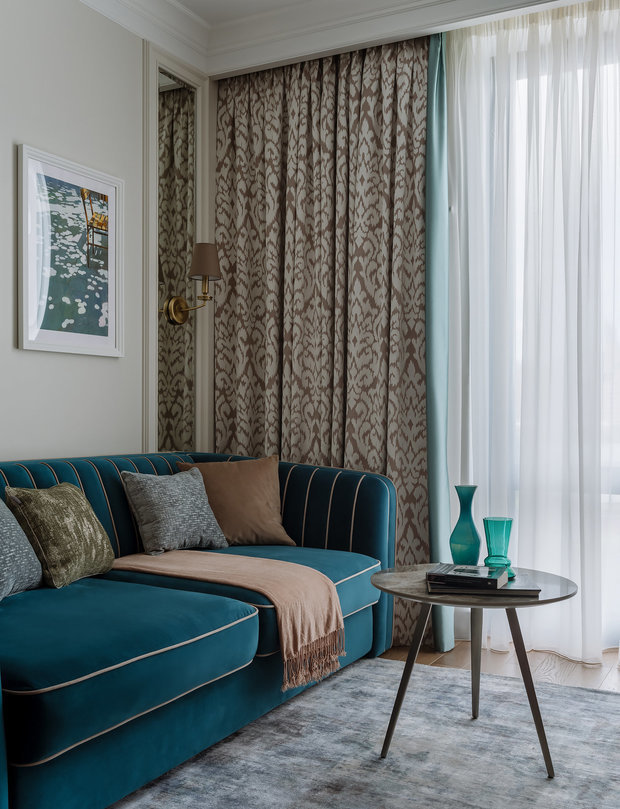 Диван насыщенного бирюзового цвета отлично смотрится со шторами и текстилем бежевого и кофейного оттенков.
