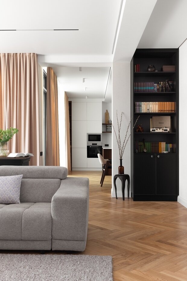 В гостиной предусмотрели книжный шкаф с библиотекой, которая досталась заказчикам по наследству.