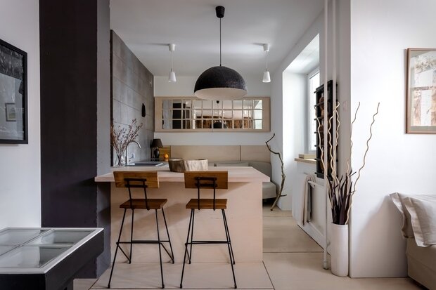 Для отделки пола, стен и мебели была использована широкоформатная светлая фанера — это позволило создать эффект целостности и монолитности в зоне кухни-гостиной.