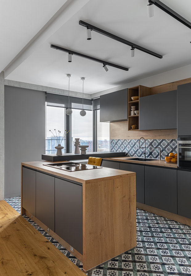 Для максимально удобного использования острова шкафы расположены с двух сторон: со стороны кухни — обычные по глубине, а с обратной — неглубокие дополнительные места хранения. 